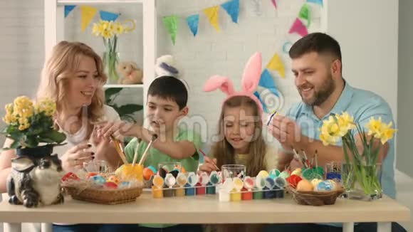 有趣的家庭孩子们戴着兔子耳朵在复活节画蛋视频的预览图