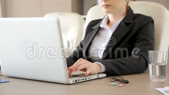 穿西装的女商人把手提电脑上的音频和麦克风连接起来视频的预览图