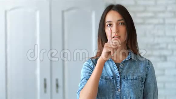 年轻漂亮的女人用手指做着无声的手势视频的预览图