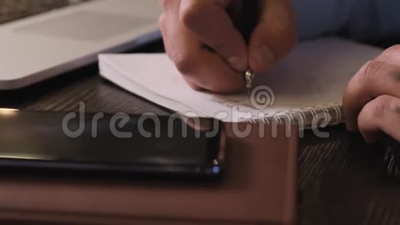 男性用钢笔在纸笔记本上做笔记视频的预览图
