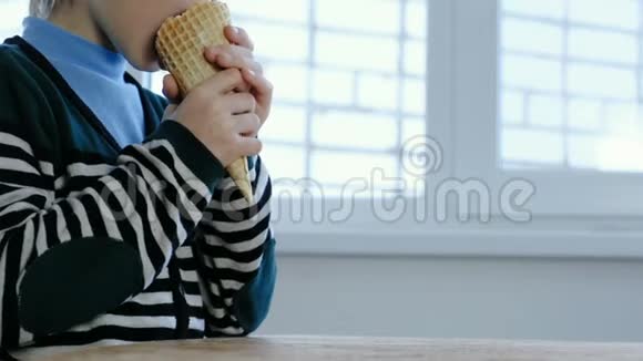 穿着条纹夹克的面目全非的男孩在家里用喇叭吃冰淇淋视频的预览图