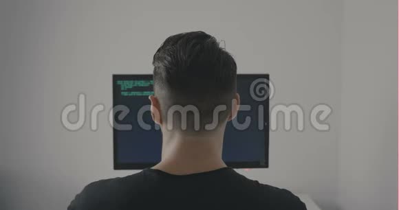 黑客程序员在办公室工作时编写绿色代码的背面视图视频的预览图