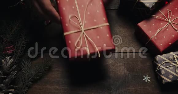 男性双手放送新年礼物木质背景新年装饰圣诞树模糊视频的预览图
