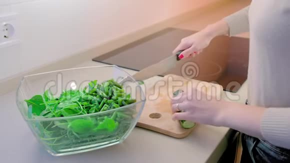 特写镜头动作缓慢未被认出的女人用一把大菜刀在木板上切黄瓜的概念视频的预览图