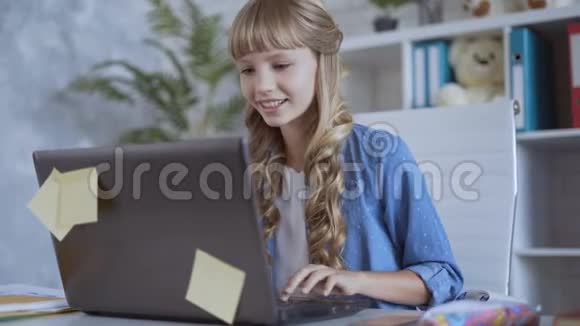 可爱的10岁女孩正在专心玩电脑游戏视频的预览图