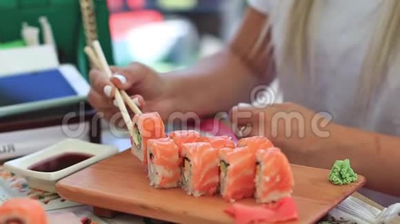 女性手拿筷子的特写镜头扣篮时髦地将寿司做成酱油视频的预览图