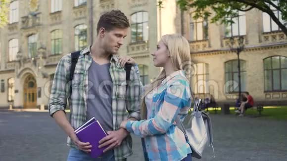 英俊的年轻男女站在大学附近聊天学生们视频的预览图