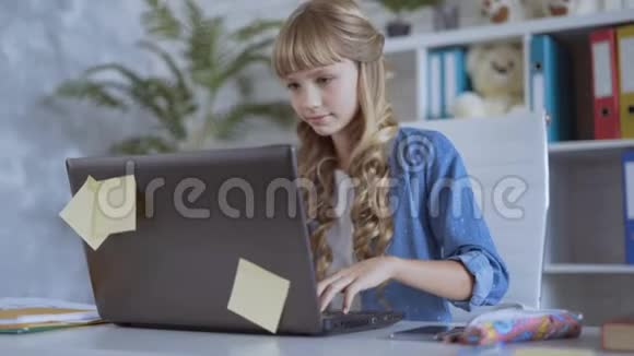 可爱的10岁女孩正在专心玩电脑游戏视频的预览图