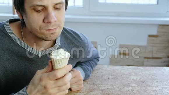年轻人坐在窗边在家吃冰淇淋前景视频的预览图