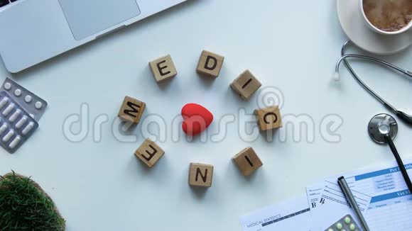 在医生桌上的玩具心脏周围移动的木立方体的药物停止运动视频的预览图