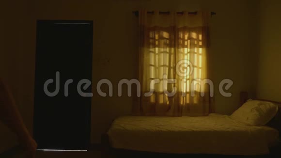 一个女人在黑暗的房间里开门房间里充满了明亮的光线视频的预览图
