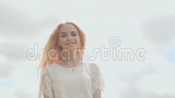 一个夏天年轻的俄罗斯女孩金发碧眼在白色的天空上摆姿势视频的预览图