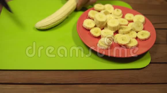 人们把香蕉切成块切割板上的薄片视频的预览图
