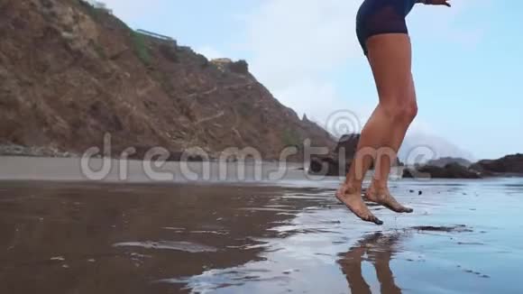积极运动的女人沿着海边的水池冲浪以保持健康和健康日落黑沙滩背景视频的预览图