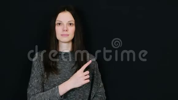 女人在微笑用手指向右显示提供文本的房间视频的预览图