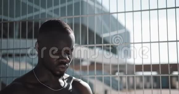 黑人疲惫的非裔美国男运动员经过艰苦的训练后喝干净的凉水交叉配合训练工作安排视频的预览图