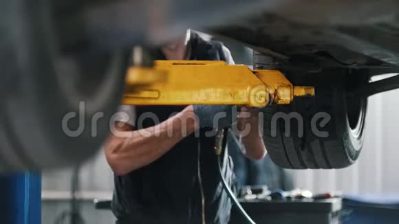 机械师在车间起重机上用螺钉固定汽车上的车轮视频的预览图