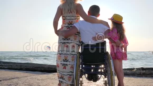 背景海上孕妇和儿童无效丈夫坐轮椅视频的预览图