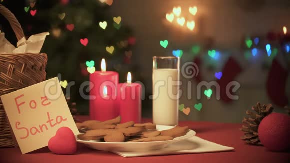 供圣诞老人在餐桌上享用牛奶和姜饼干这是可爱的家庭传统视频的预览图