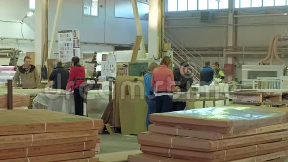 男女工人讨论在大型车间工作的过程制造木门的过程视频的预览图