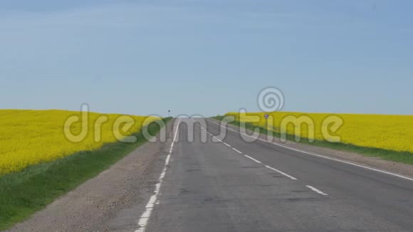 在油菜黄田之间的高速公路与蓝天视频的预览图
