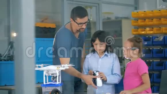孩子们在学校探索复印机无人机与老师在一个技术课视频的预览图