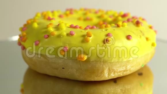 旋转的甜甜圈与不同的填充在镜面上美味的甜面圈在盘子上旋转明亮和明亮视频的预览图
