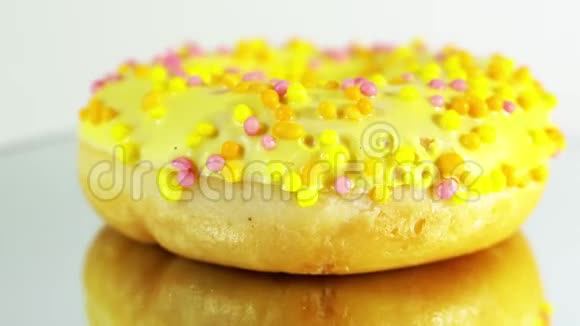 旋转的甜甜圈与不同的填充在镜面上美味的甜面圈在盘子上旋转明亮和明亮视频的预览图