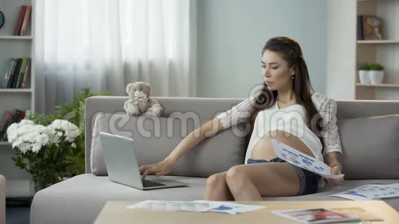 怀孕的妇女在笔记本电脑上工作手持图表事业成功视频的预览图