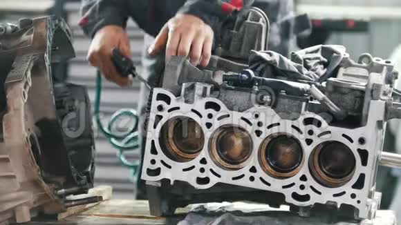 机械师润滑汽车发动机气门座的齿轮并修理它视频的预览图