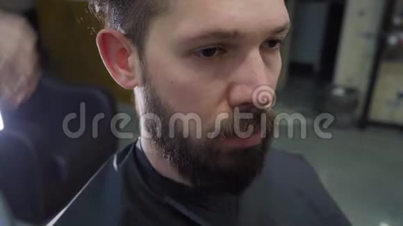 一个年轻人理发店用剪刀剪头发和胡须视频的预览图