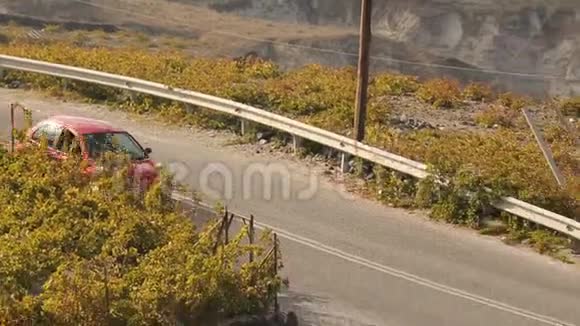 一辆红色的小汽车很快就出现了在山丘后面的路上行驶视频的预览图