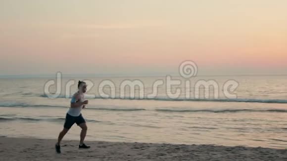 夏天运动员在海边跑步在沙滩上慢跑视频的预览图