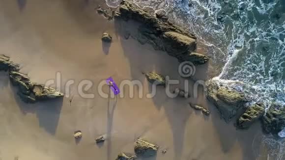 波浪在岩石上翻滚女人在海滩上的身影视频的预览图