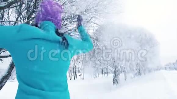 微笑的女孩在公园里享受冬天的雪视频的预览图