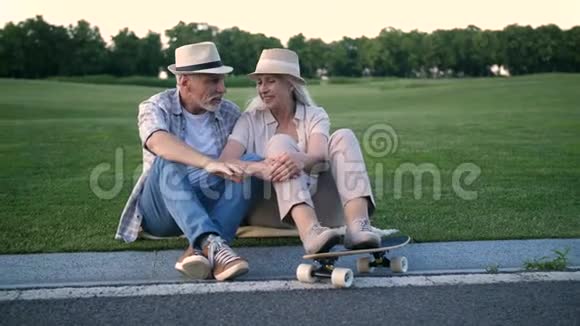 时髦的老夫妇坐在滑板旁边视频的预览图