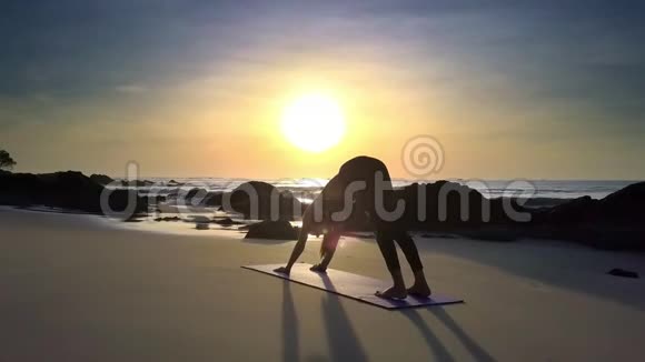 阳光明媚的阳光灿烂的女孩在做瑜伽海滩视频的预览图