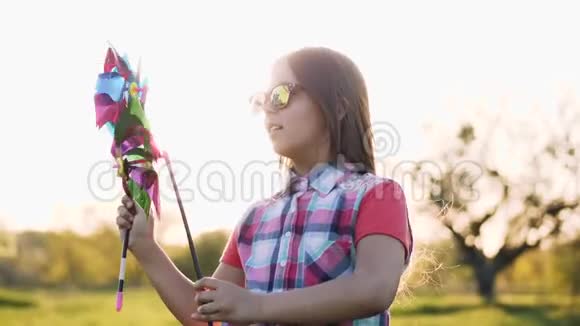 带着彩色玩具风车跳舞的女孩视频的预览图
