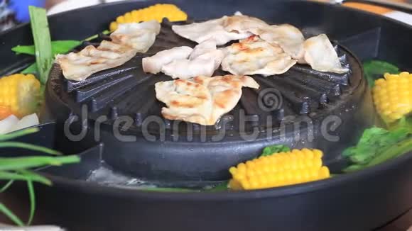 肉培根和条纹猪肉烤在黑色电烤架与蔬菜和玉米煮沸在它的一侧视频的预览图
