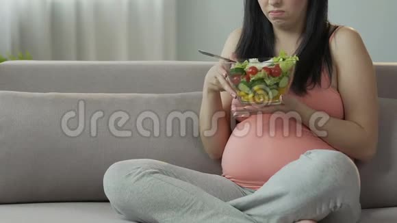 期待女人在沙发上吃沙拉并有恶心食物中毒视频的预览图