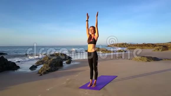 女子在蓝天清洁沙滩上做瑜伽视频的预览图