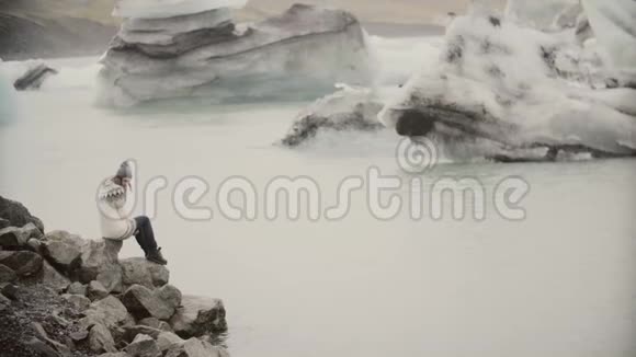 年轻快乐的女人走在冰泻湖的岸边在洛帕皮萨观光冰岛的游客视频的预览图