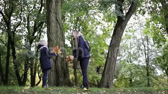 母女俩在秋天公园里吐黄叶视频的预览图