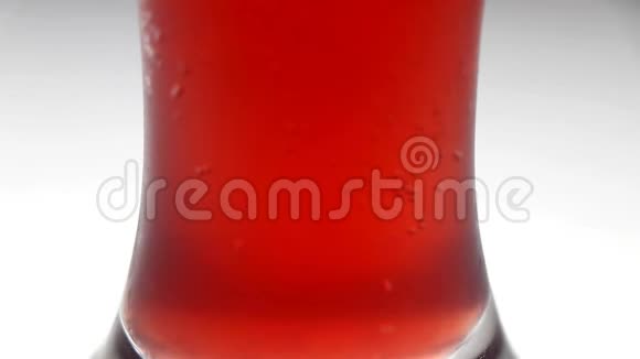 红色的啤酒泡沫上升玻璃杯里的红色汽水视频的预览图