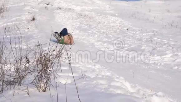 女孩在雪中滑下山坡女孩冬天在公园里玩视频的预览图