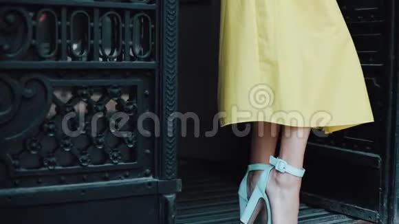 一位迷人的年轻女子站在一个欧洲城市的街道上穿着一件黄色衣服看着一幅画视频的预览图