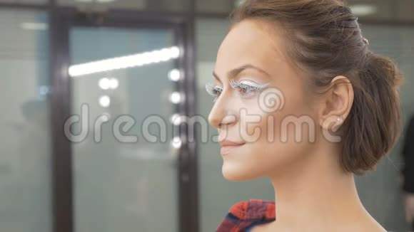 一个睫毛很大的年轻女孩的肖像她用一只眼睛眨眼慢动作视频的预览图