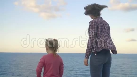 母女俩站在一座山顶上望着大海日落希腊克里特岛视频的预览图