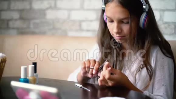 戴耳机的女孩在电话里聊天做指甲用免费和复印的空间剪指甲视频的预览图