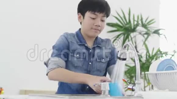 亚洲小男孩在家厨房洗碗生活方式概念视频的预览图